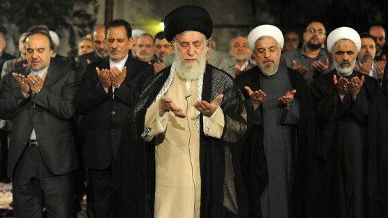 Iran’s ruler Ali Khamenei leading a prayer with reformist figures behind him