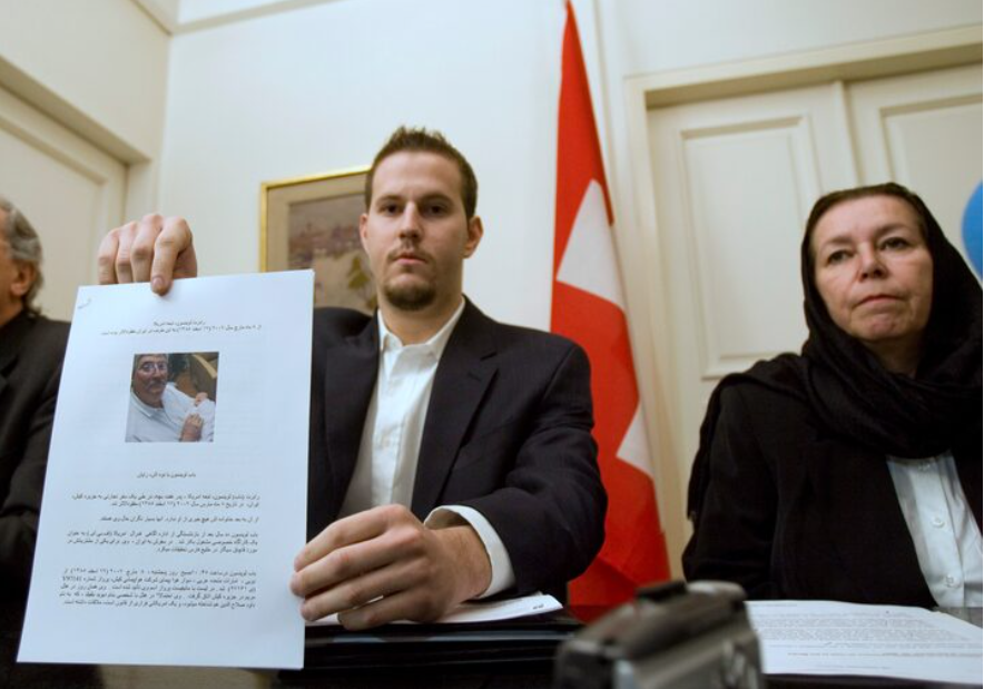 Christine Levinson (R), wife of former FBI agent Robert Levinson, watches as her son Daniel Levinson displays a web print of his father's picture to journalists while attending a news conference at Switzerland's embassy in Tehran December 22, 2007. REUTERS/Morteza Nikoubazl (IRAN) Purchase Licensing Rights