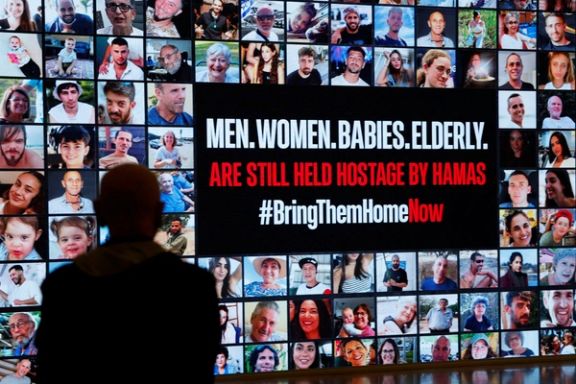 A person stands in front of pictures during a demonstration to demand the liberation of hostages who are being held in the Gaza Strip after they were seized by Hamas gunmen on October 7, in Tel Aviv, November 21, 2023.