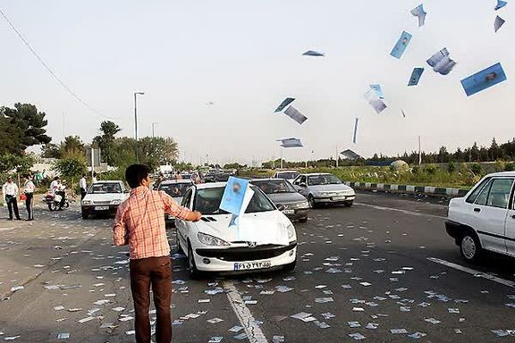 A man distributing election campaign flyers of candidates running for a seat at the Iranian parliament in Tehran