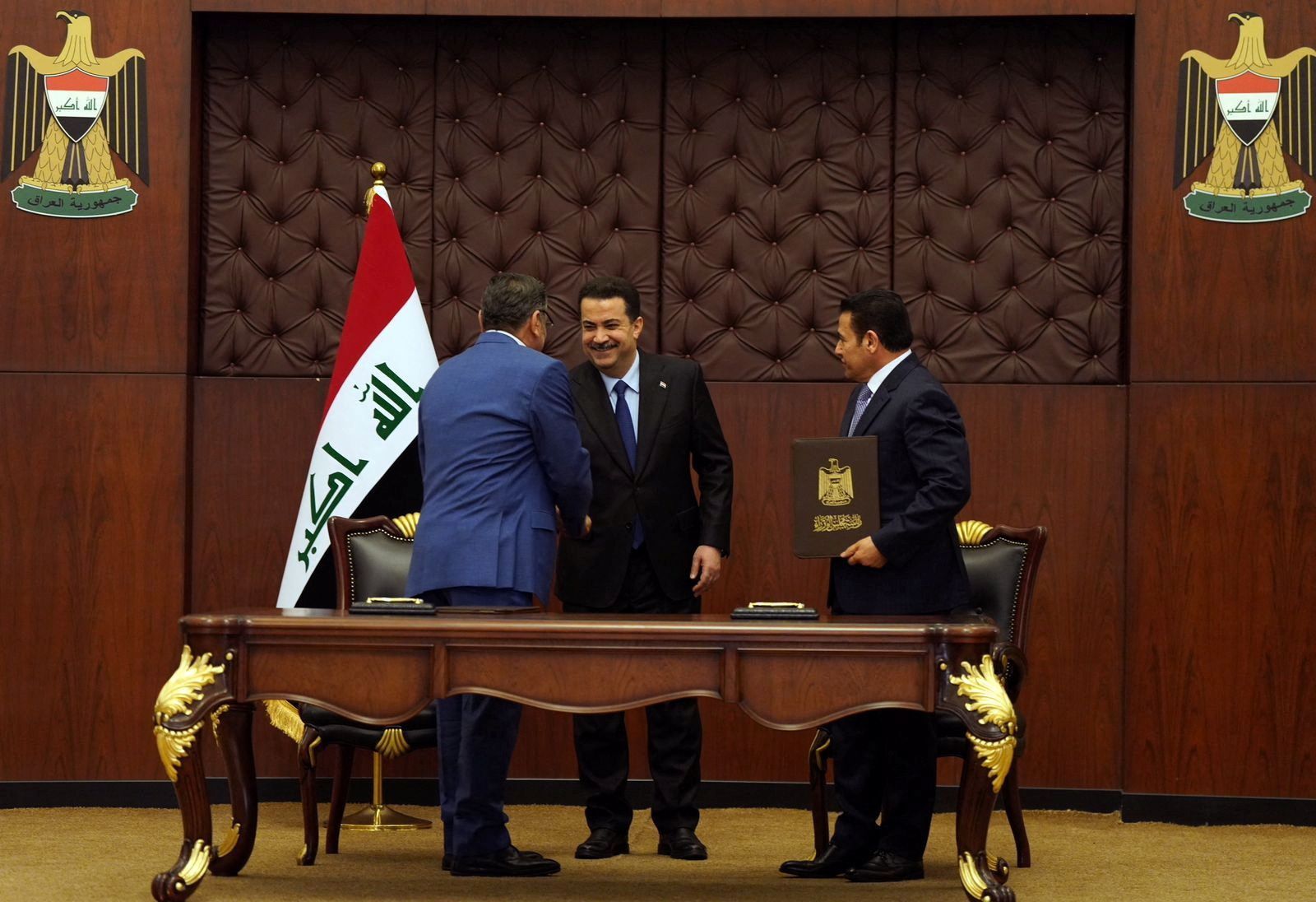 Iraq's National Security Adviser Qasim al-Araji looks on as Iraqi Prime Minister Mohammed Shia al-Sudani greets Iran's Supreme National Security Council secretary Ali Shamkhani during a signing of the security agreement that includes coordination in protecting the common borders between the two countries, in Baghdad, Iraq, March 19, 2023.