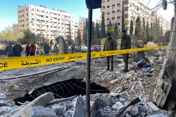 Police officers stand amid the rubble of a damaged building at the site of a rocket attack in the Kafr Sousa neighbourhood of central Damascus, Syria, February 19, 2023