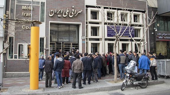 People in Tehran lining up to buy US dollars from a bank exchange office.