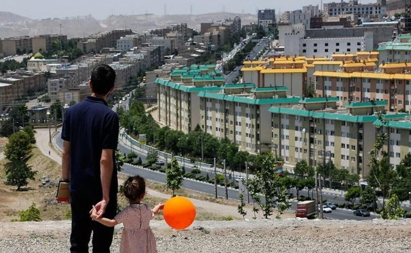 File photo of a father and child overlooking apartment blocks in Tehran amid soaring rents and deepening economic pressure on Iranian households.