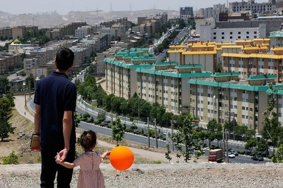 File photo of a father and child overlooking apartment blocks in Tehran amid soaring rents and deepening economic pressure on Iranian households.