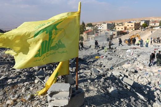 A Hezbollah flag flutters at a site damaged in the aftermath of an Israeli strike on the town of Al-Ain in the Baalbek region, in Lebanon, November 6, 2024