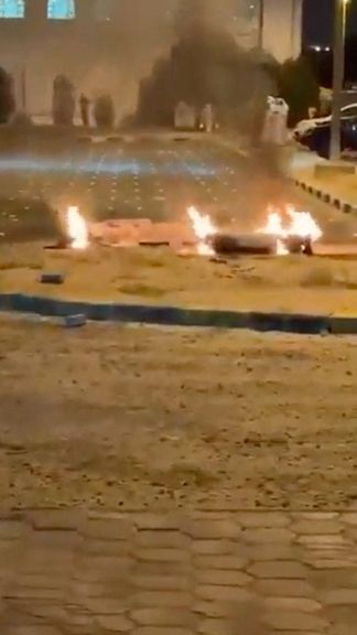 Debris burns on the ground in a parking lot following reports of missile and drone attacks, in Sabah Al Nasser, Kuwait on June 3, 2026, in this screengrab obtained from a social media video.