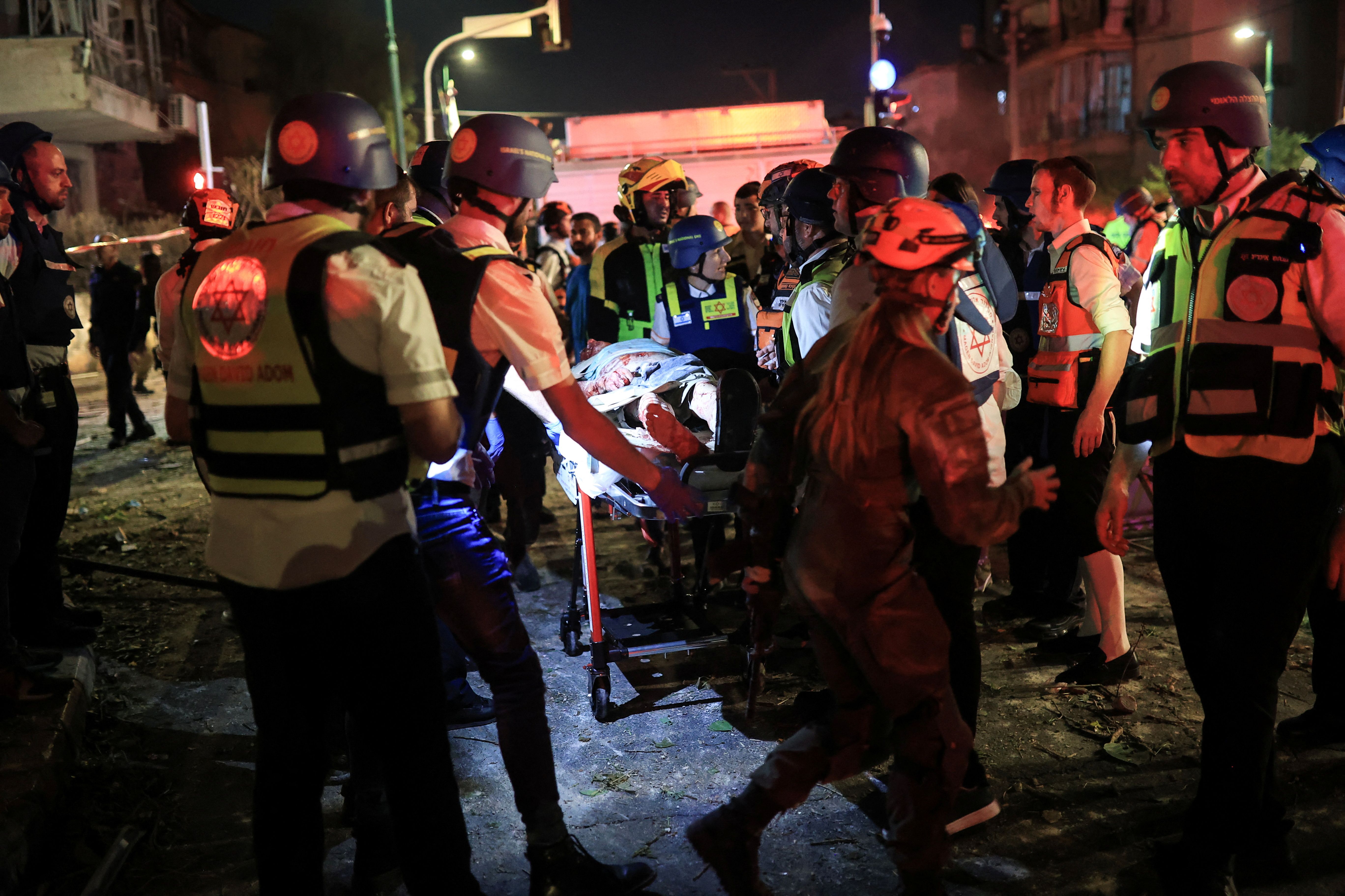 Rescue and security personnel carry a wounded person at an impact site following missile attack from Iran on Israel, in Ramat Gan, Israel June 13, 2025 