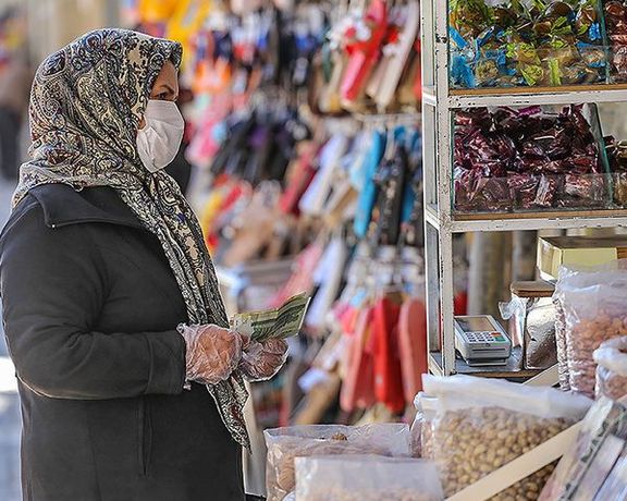 A woman shopping in Tehran with Iranian currency in hand