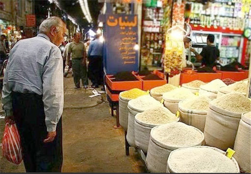 An elderly man checking rice prices at a market in Iran (Undated)
