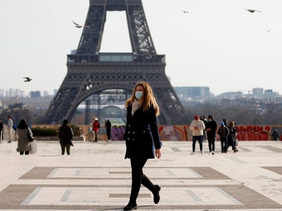 A woman walks in front of the Eiffel tower at the Trocadero in Paris in February 2021.