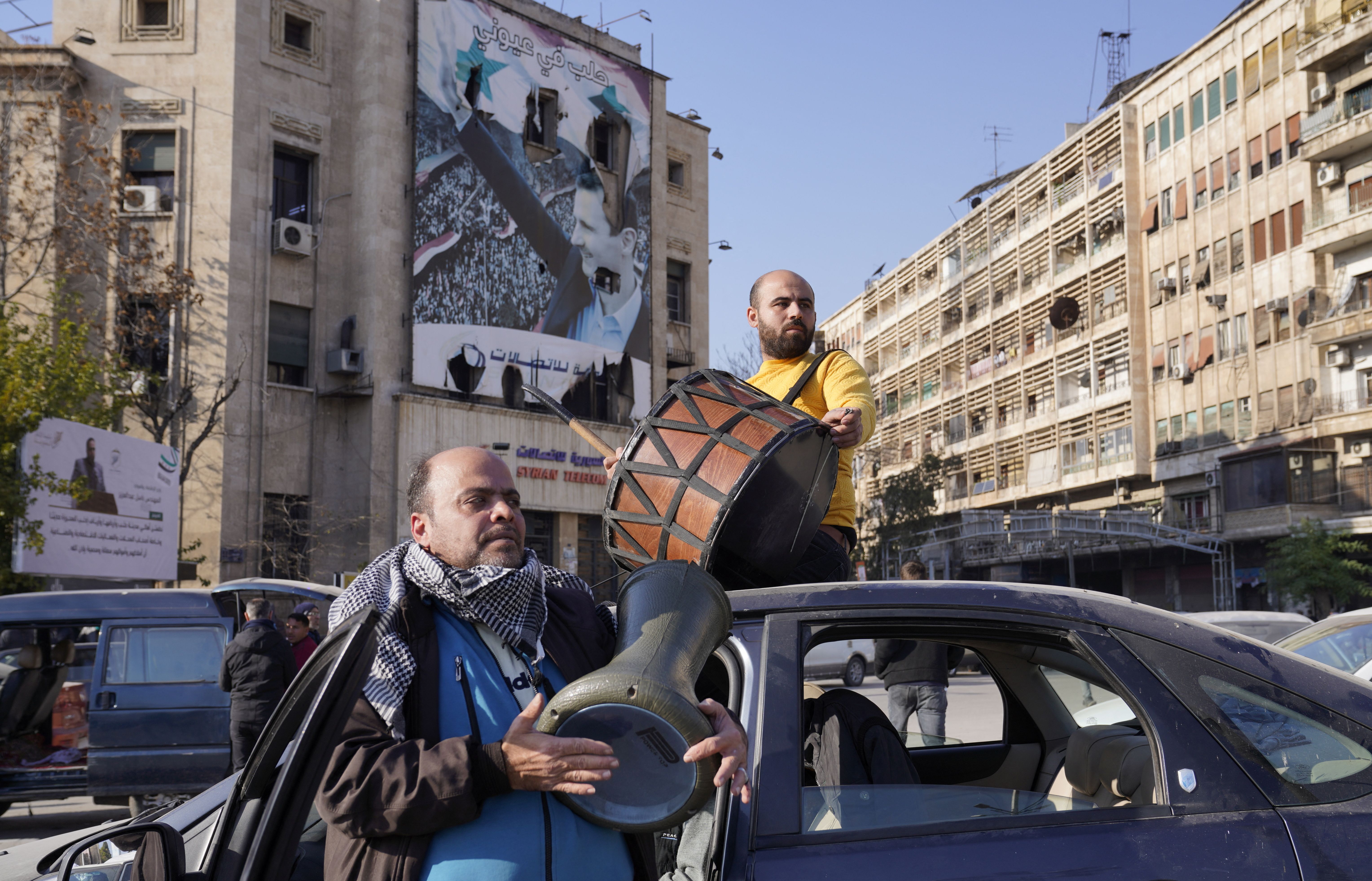 People celebrate along a street in Aleppo, Syria December 8, 2024. 