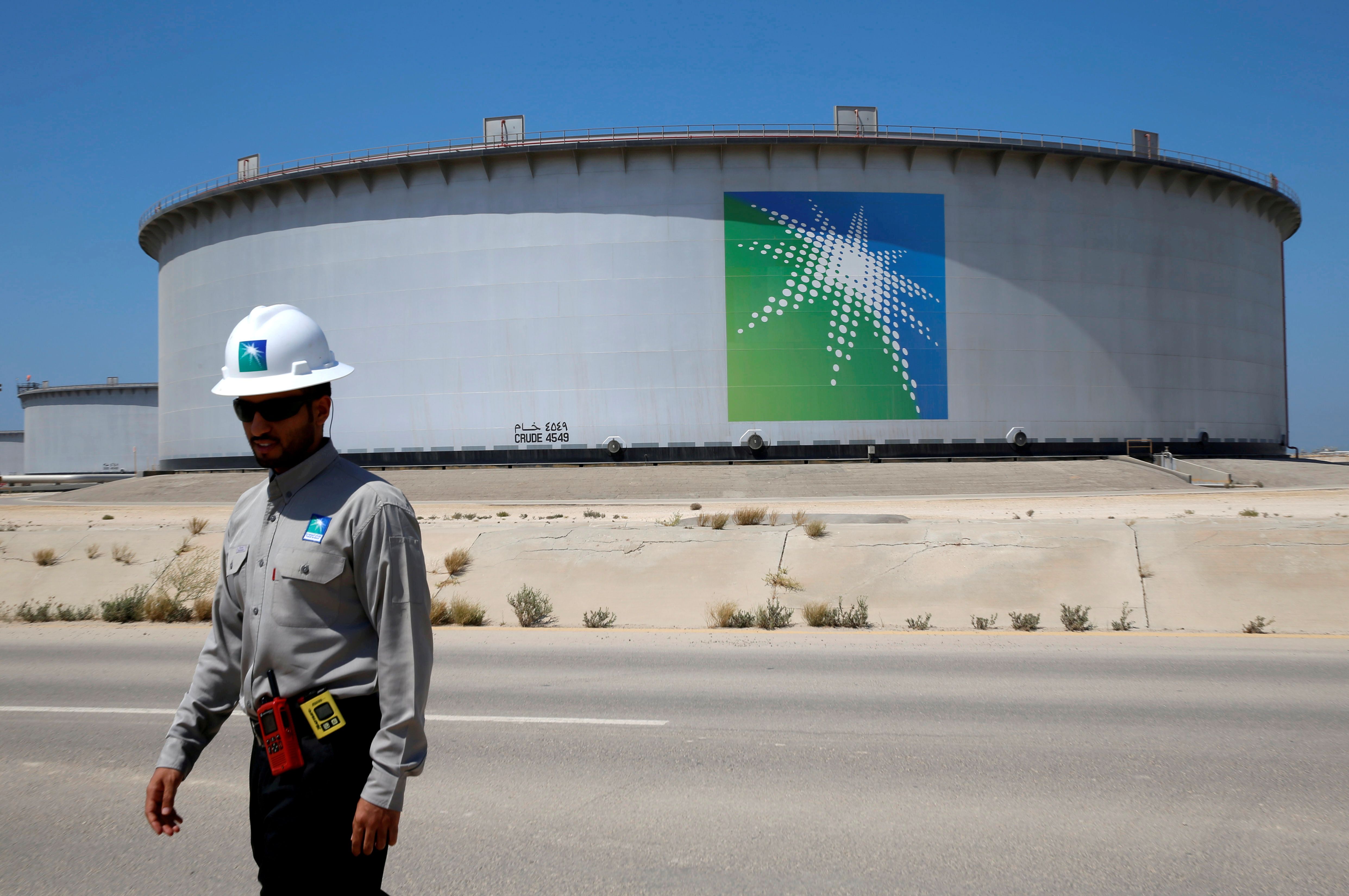 An Aramco employee walks near an oil tank at Saudi Aramco's Ras Tanura oil refinery and oil terminal in Saudi Arabia May 21, 2018. 