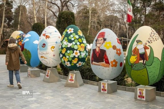 A woman is walking past symbolic decorated Nowruz eggs, one of the traditions of Nowruz, in Tehran (March 2024)