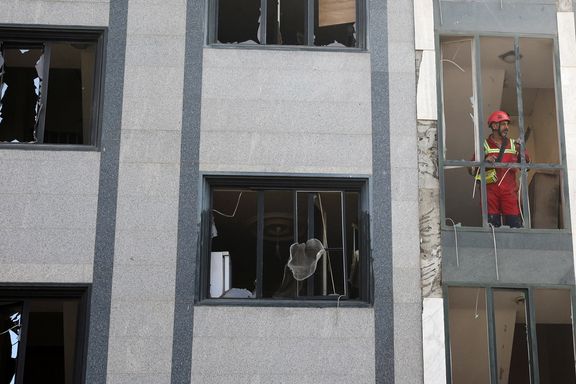 A rescuer looks out from a damaged building in the aftermath of Israeli strikes, in Tehran, Iran, June 13, 2025.
