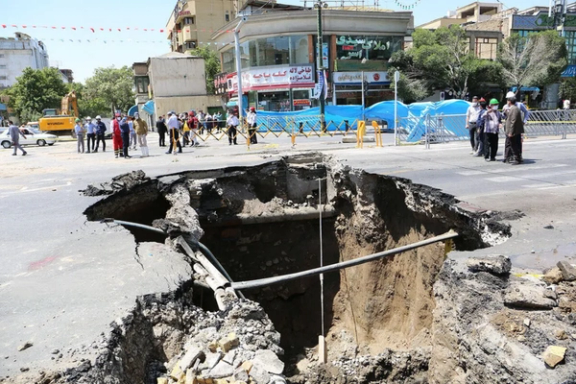 A large sinkhole caused by land subsidence opens beneath a street in Iran.