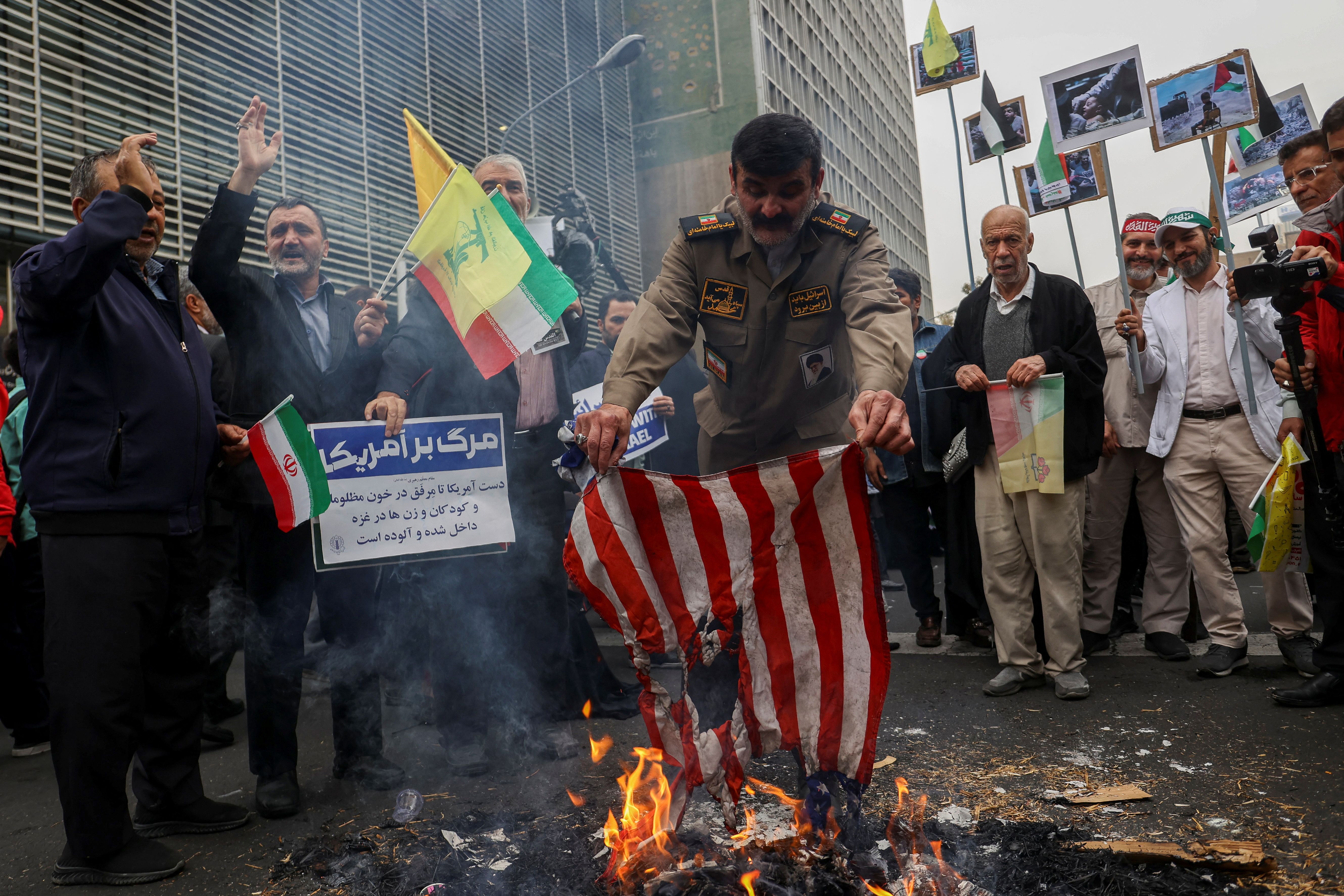 An Iranian man burns an American flag during the 44th anniversary of the U.S. expulsion from Iran, in Tehran, Iran November 4, 2023.