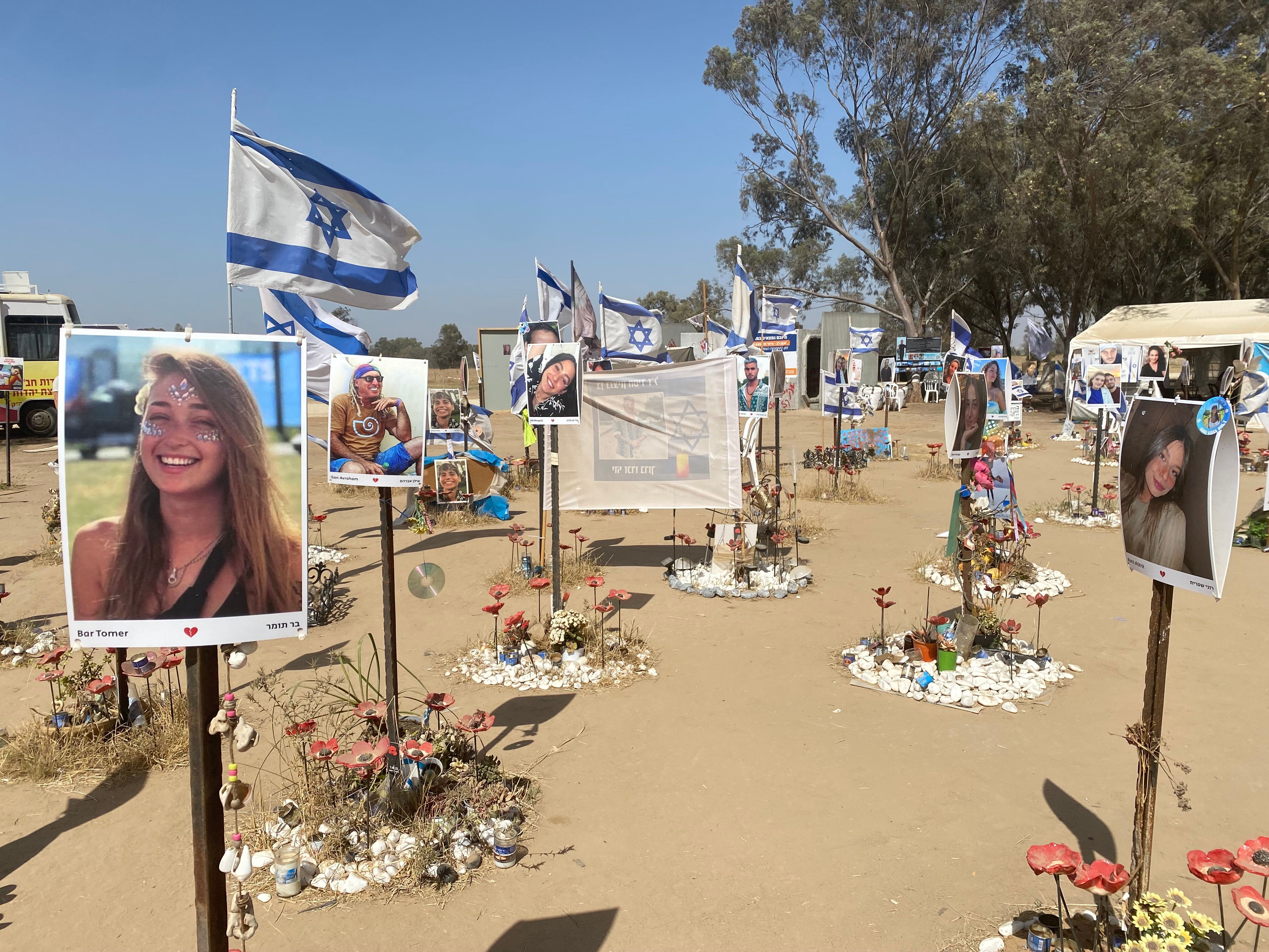 Photos of people killed and taken hostage by Hamas militants, displayed at the site near Kibbutz Re'im