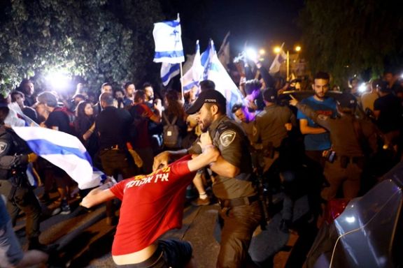 A demonstrator scuffles with a police officer as people demonstrate on the 'Day of National Resistance' in protest against Israeli Prime Minister Benjamin Netanyahu and his nationalist coalition government's judicial overhaul, in Jerusalem July 18, 2023.
