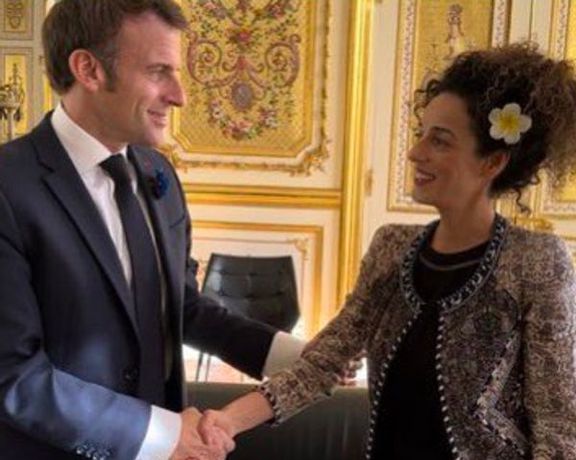 President Emmanuel Macron shaking hands with Iranian activist Masih Alinejad