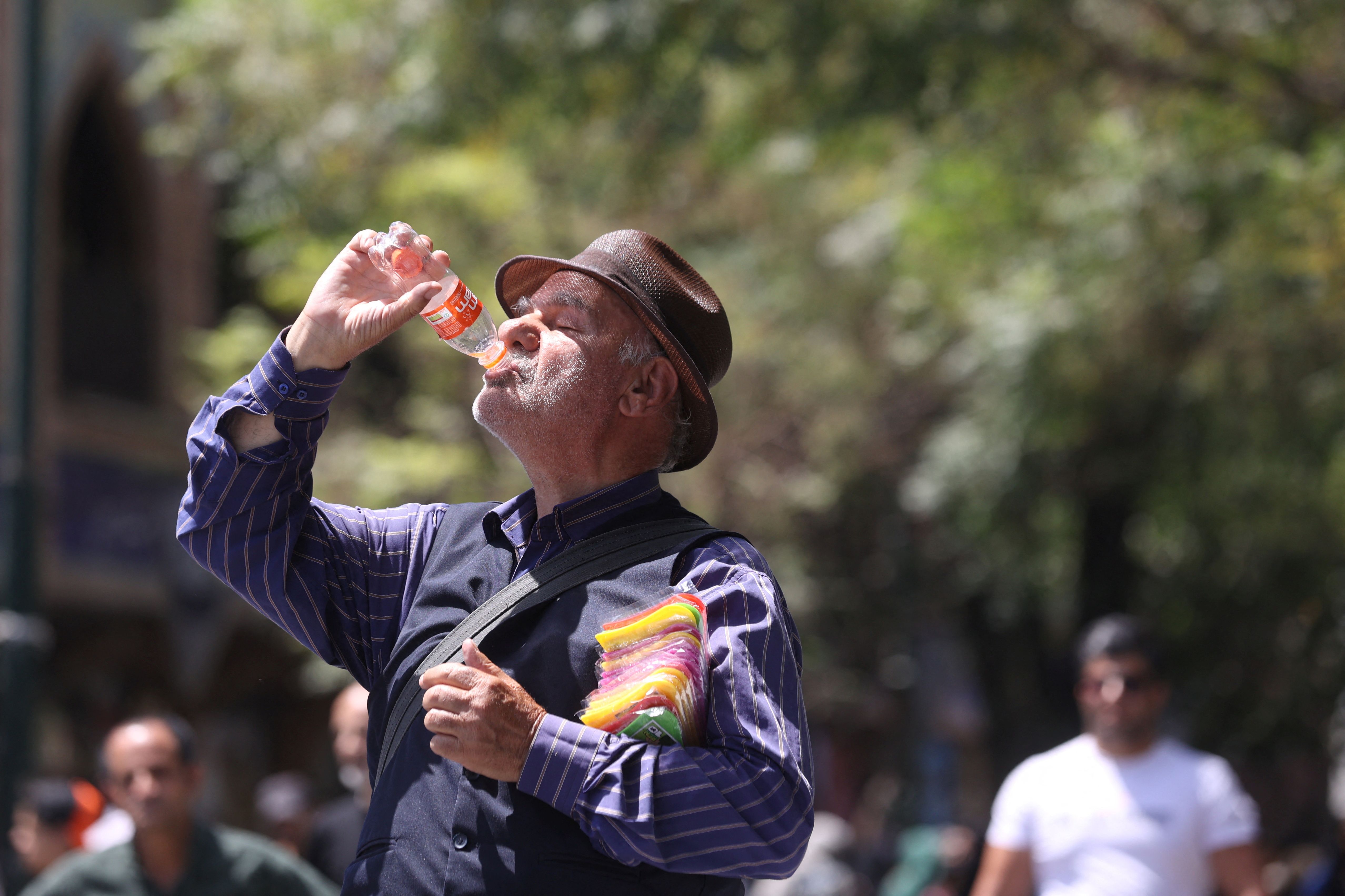 An Iranian man drinks soda during the heat surge in Tehran August 2, 2023.