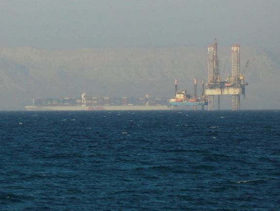 A container ship crosses an oil platform at the Gulf of Suez towards the Red Sea before entering the Suez Canal, outside of Cairo, Egypt September 1, 2020.