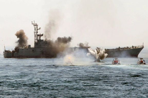 An Iranian warship and Revolutionary Guards speed boats take part in a naval war game in the Persian Gulf and the Strait of Hormuz, southern Iran, April 2010.