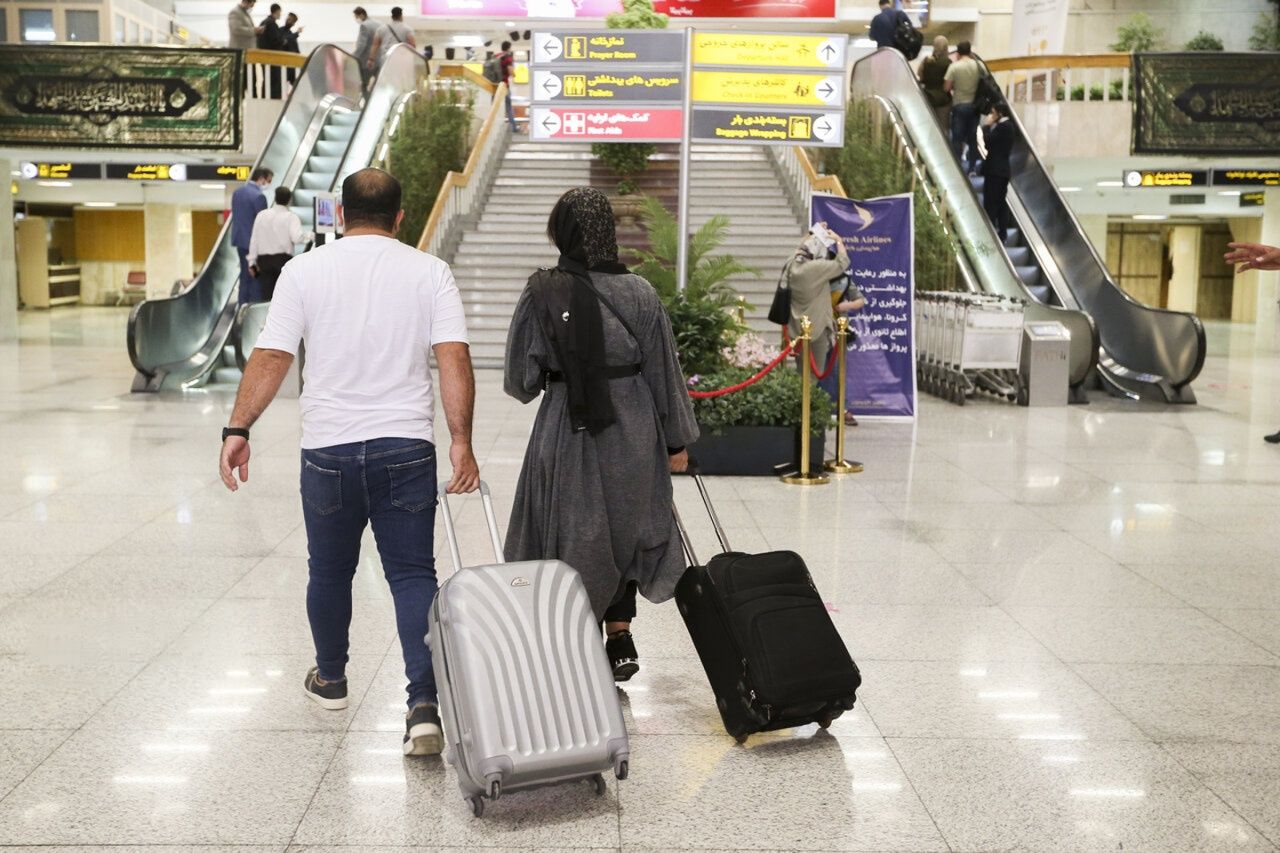 Travelers walk with their luggage inside an airport departure terminal in Iran. (undated)