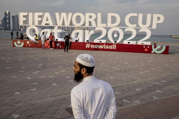 A man is pictured in front of a FIFA World Cup Qatar 2022 sign in Doha, November 17, 2022.