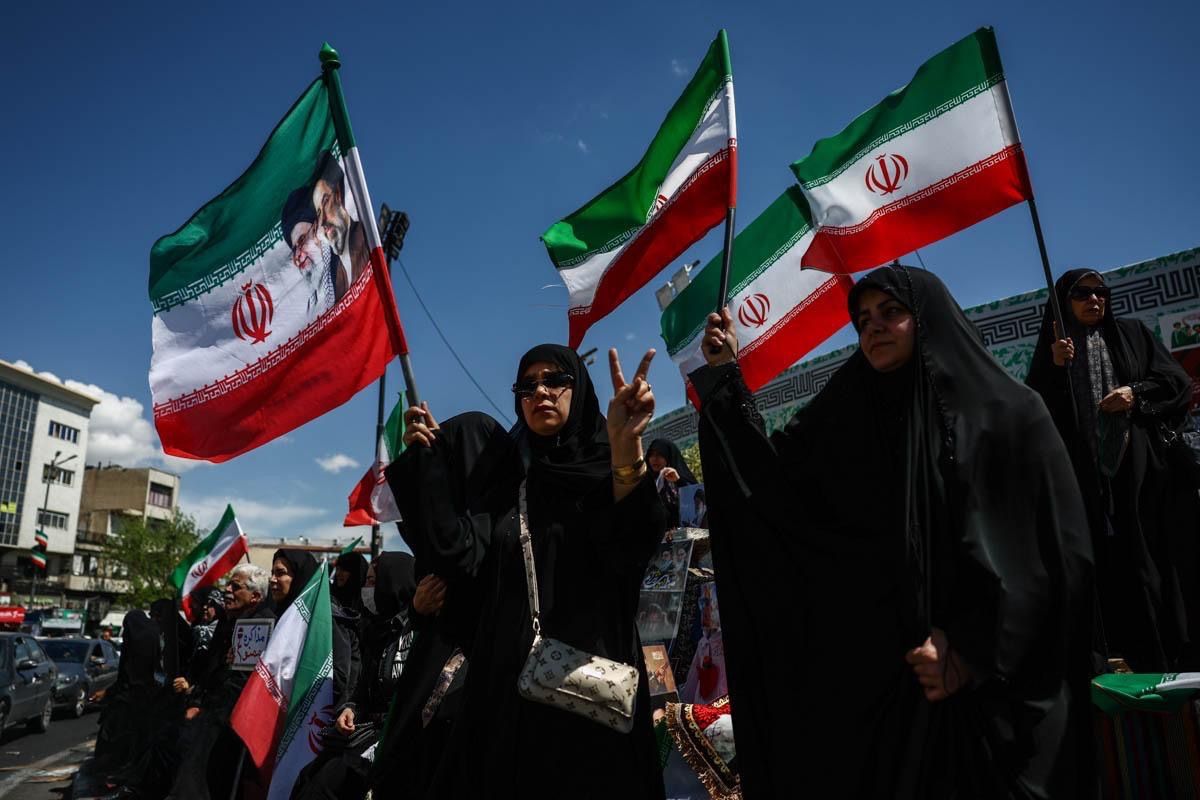 Supporters of Iran’s government wave national flags during a rally in Tehran after authorities announced a two-week ceasefire in the war with the United States and Israel, April 8, 2026